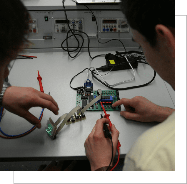 Two people working on electronics in a lab.